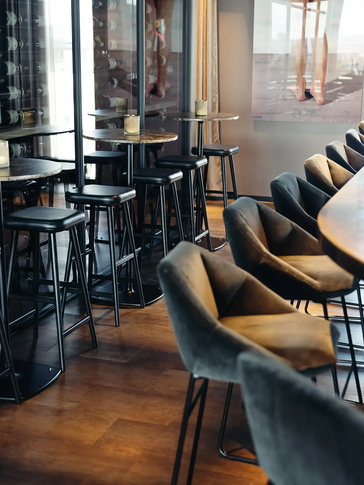 Integrated wine storage with high seating in restaurant bar, combining product display and guest experience.
