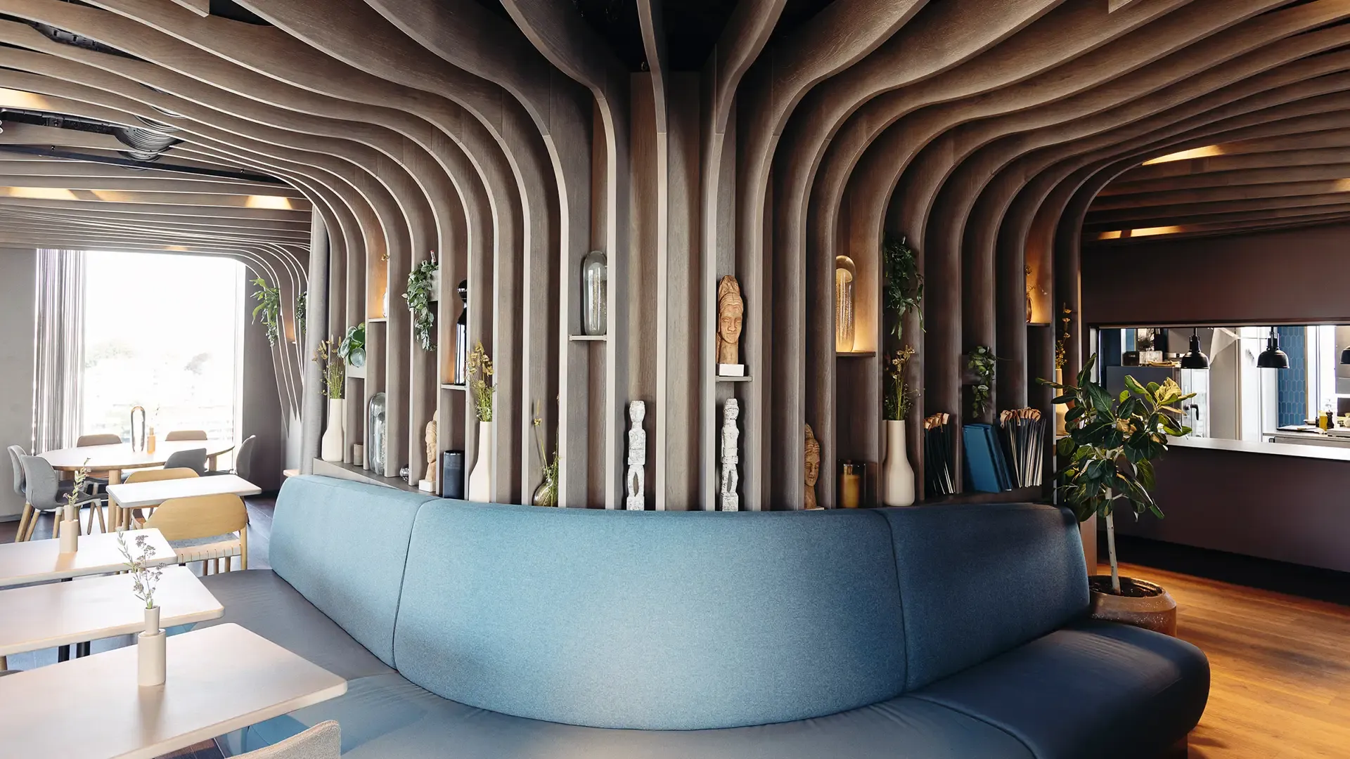Restaurant interior featuring custom ceiling panels, integrated shelving and bench seating for cohesive design and storage.