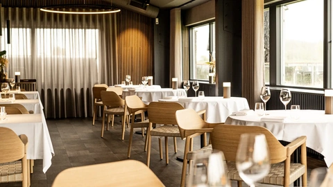 Exclusive nordic style restaurant design with oak furniture and white tablecloths at HimmerRiget.