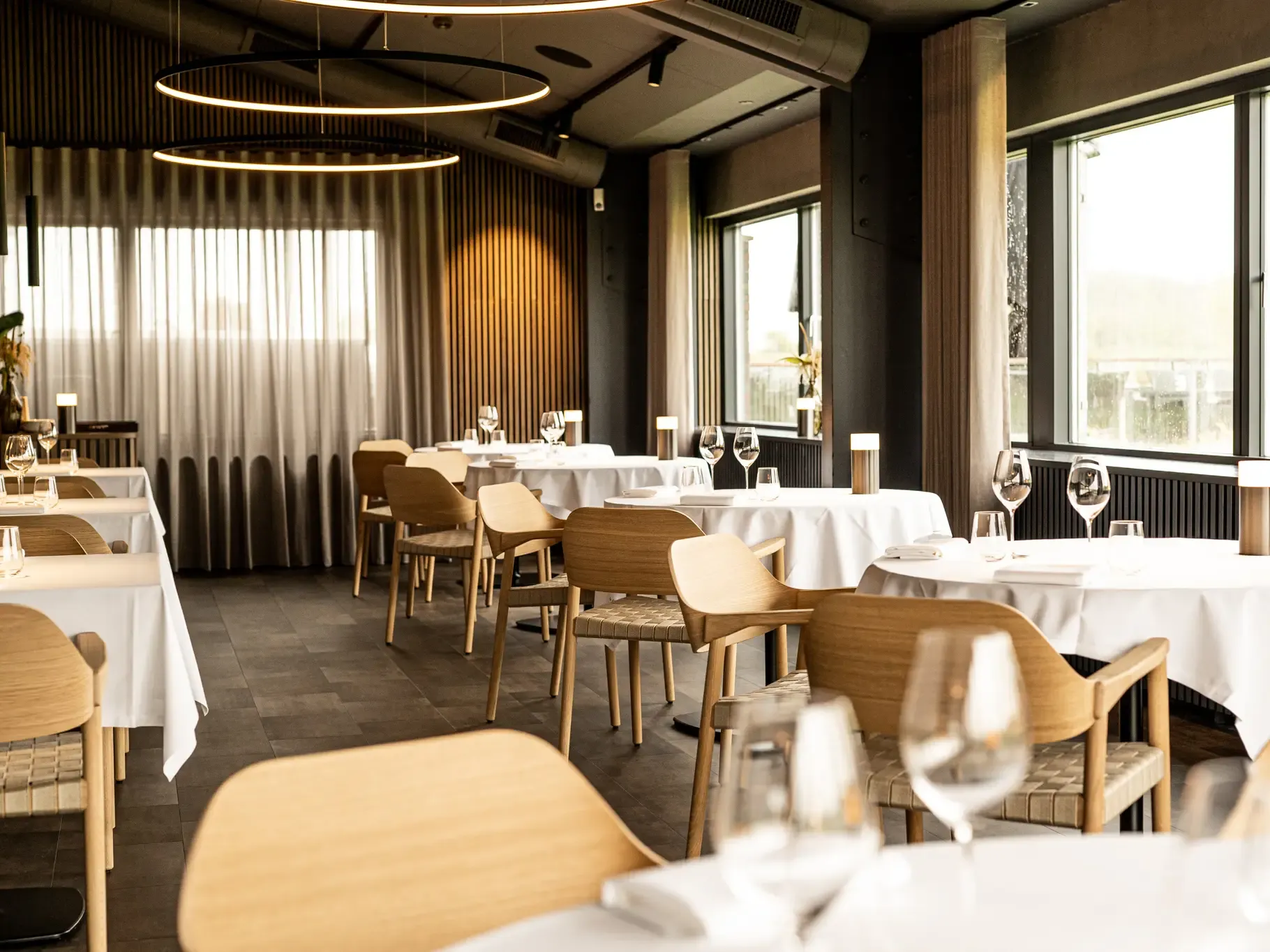Exclusive nordic style restaurant design with oak furniture and white tablecloths at HimmerRiget.