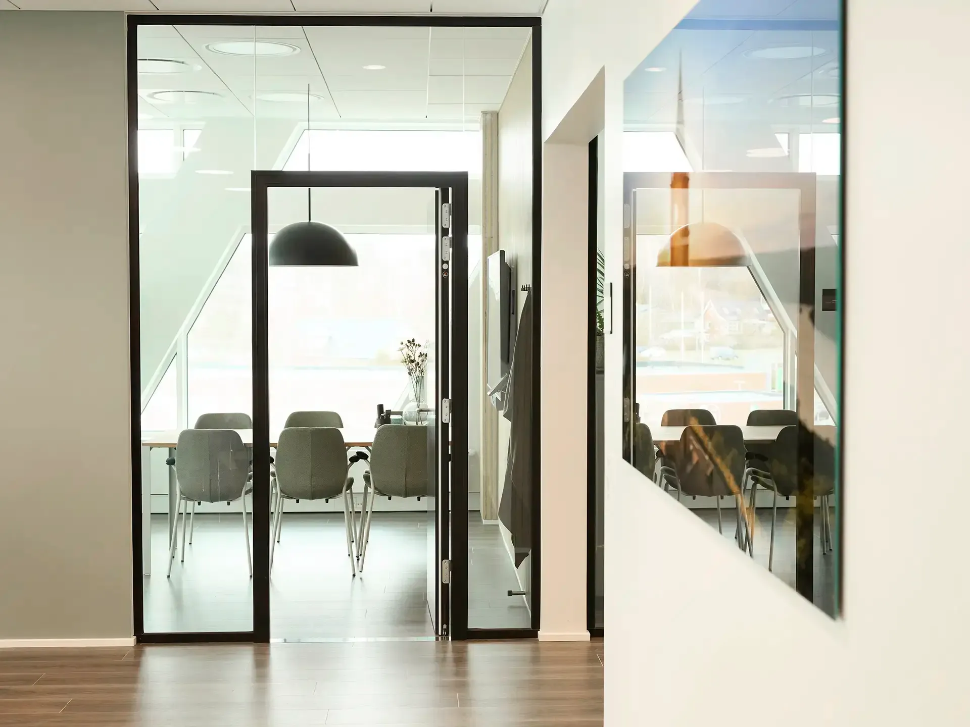 Office conference room with glass walls and minimalist interior design, creating a professional and transparent workspace.