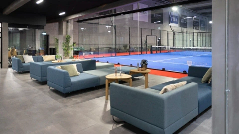 Lounge area with comfortable sofas and warm lighting, part of Match Padel Center’s modern interior design by Third.space.