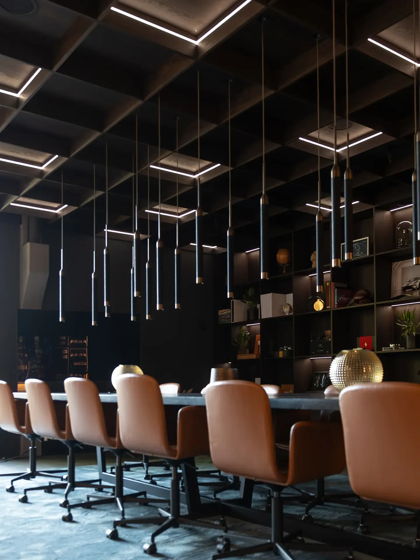 Exclusive meeting room design with long table, designer chairs, and acoustic ceiling.