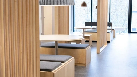 Modern student living interior with bespoke plywood furniture and integrated seating zones.
