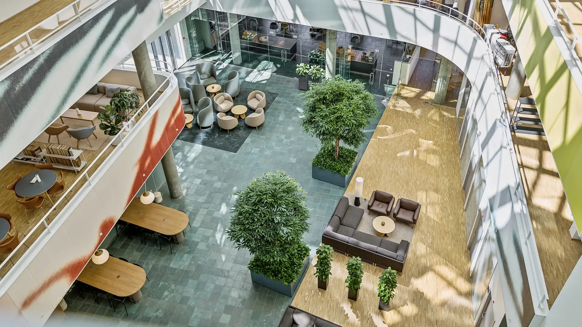 Overhead view of office foyer with lounge seating and greenery, designed to optimize corporate workspaces.