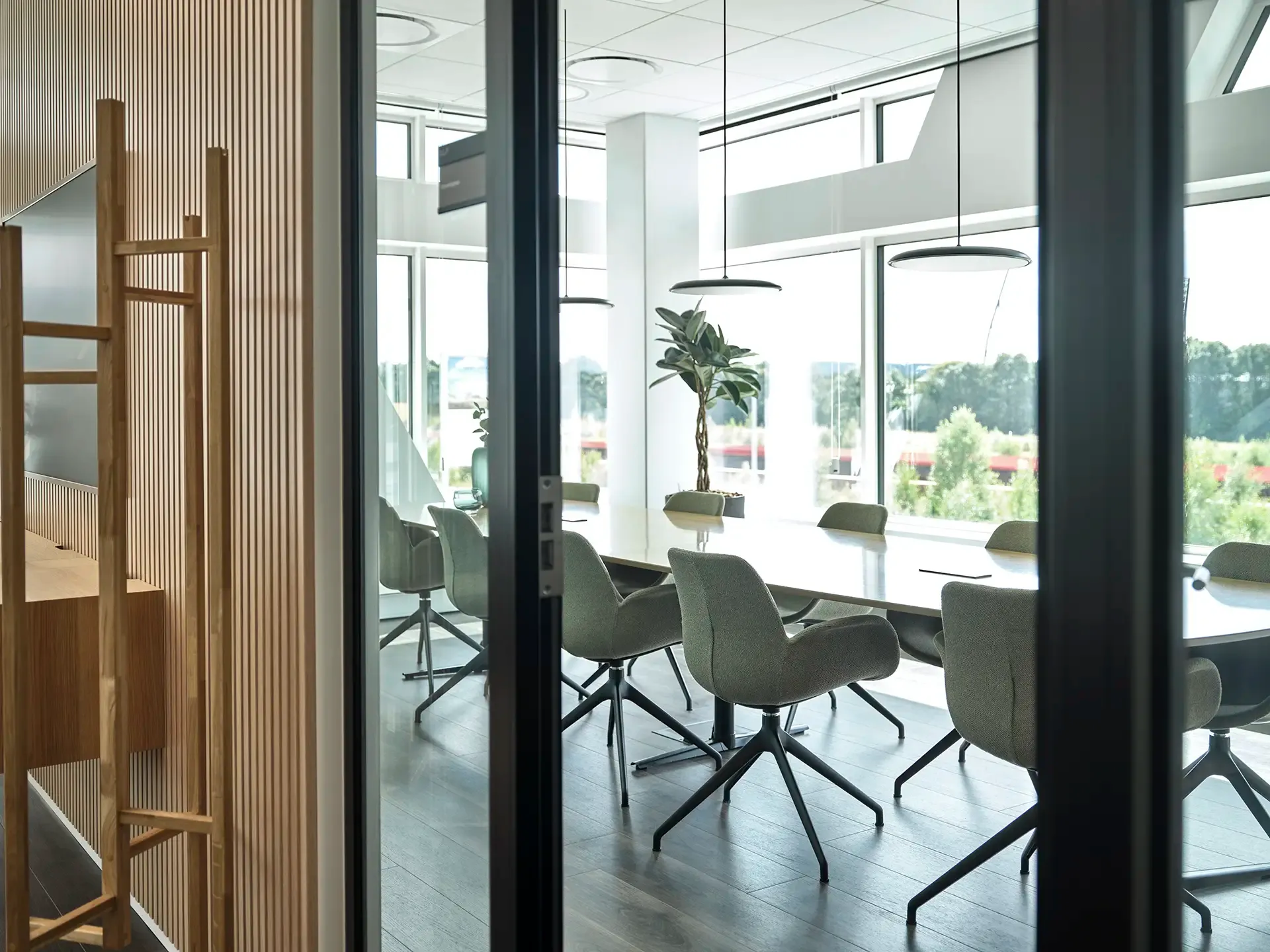 Office conference room with glass wall and natural light, delivering a bright, professional and collaborative meeting space.