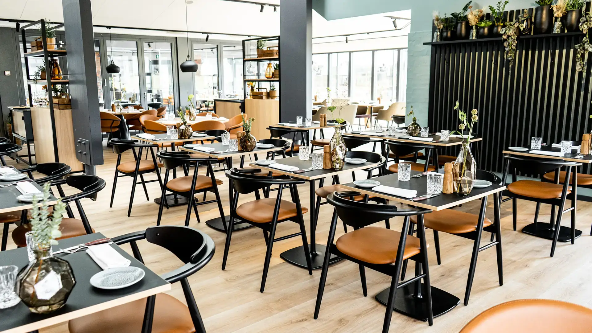 Nordic restaurant design with black dining chairs light oak wood and natural light