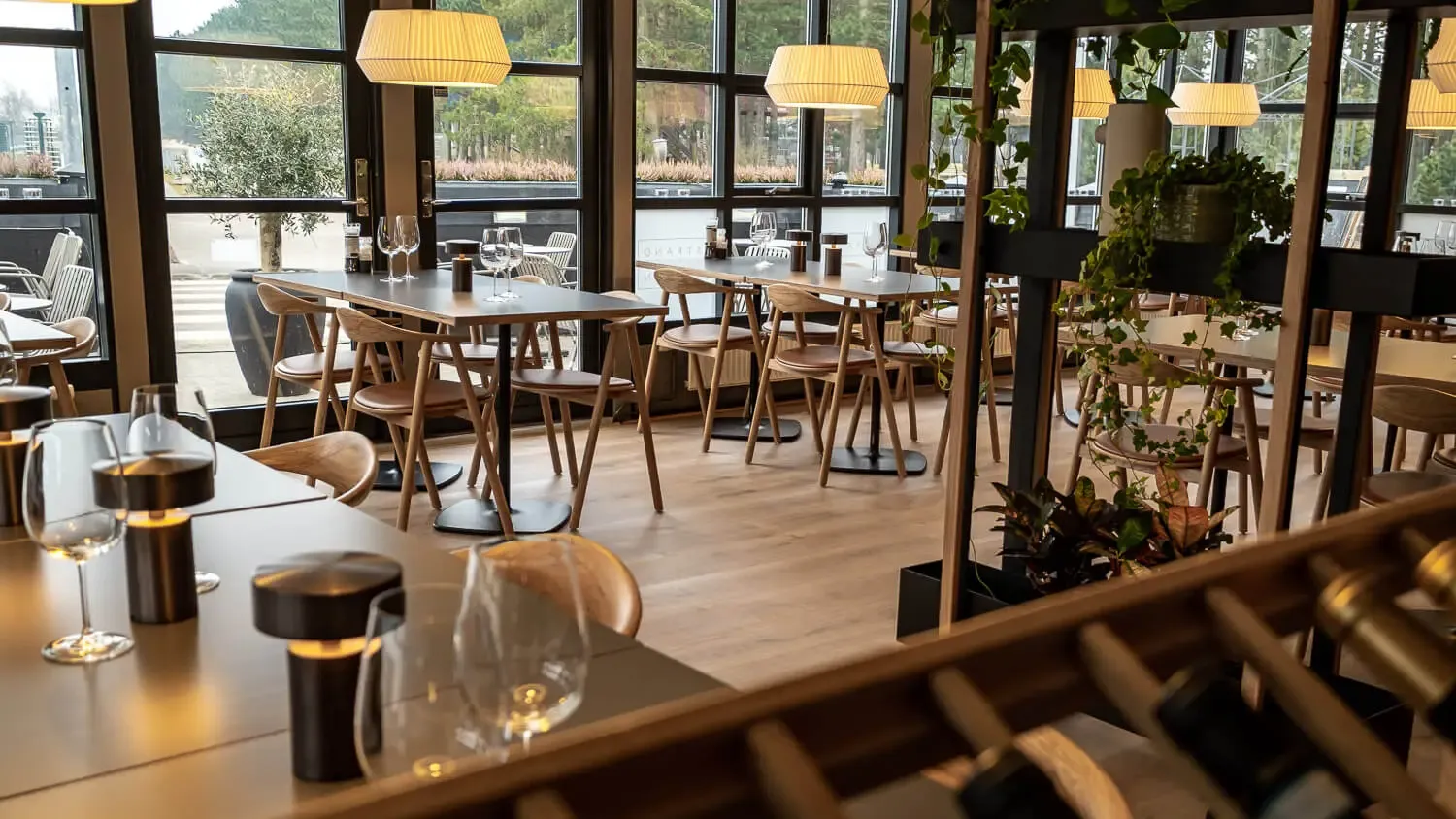Flexible dining layout with Scandinavian oak furniture and warm lighting, designed for multifunctional spaces in camping resorts and leisure facilities.