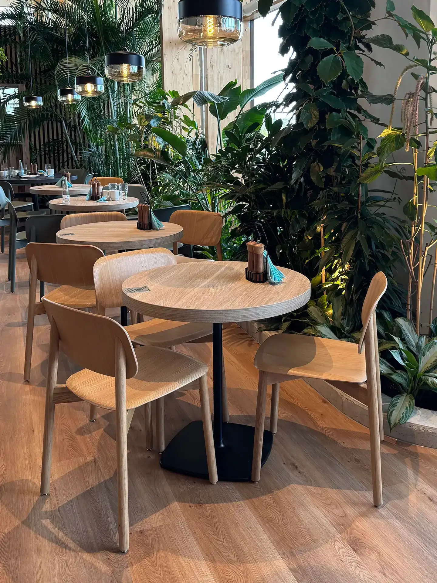 Dining area with biophilic interior design and contract-grade furniture integrated with indoor planting at Nordborg Resort.