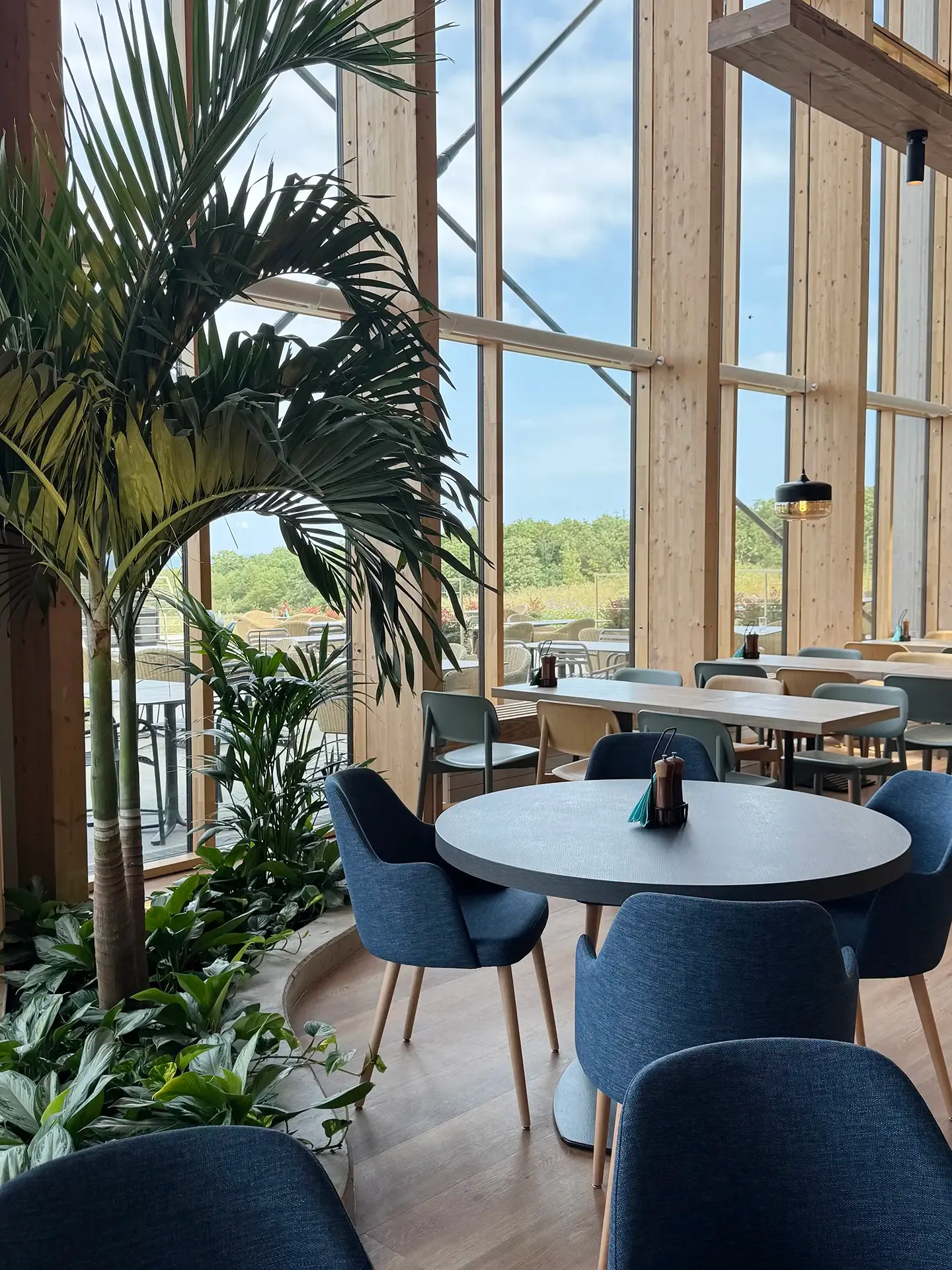 Commercial dining furniture specified for a high-use resort environment with integrated planting at Nordborg Resort.