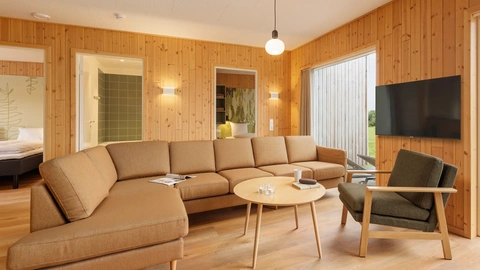 Soft seating and coffee table specified for durability and comfort in a resort cottage living area at Nordborg Resort.