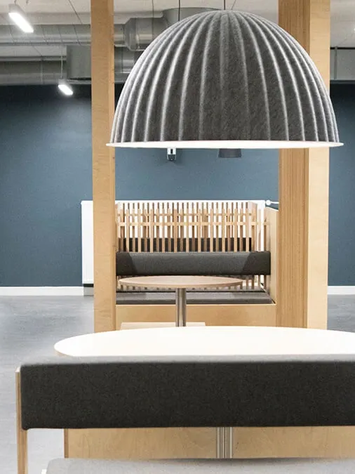 Student accommodation lounge booth seating with oak frame and acoustic pendant light.