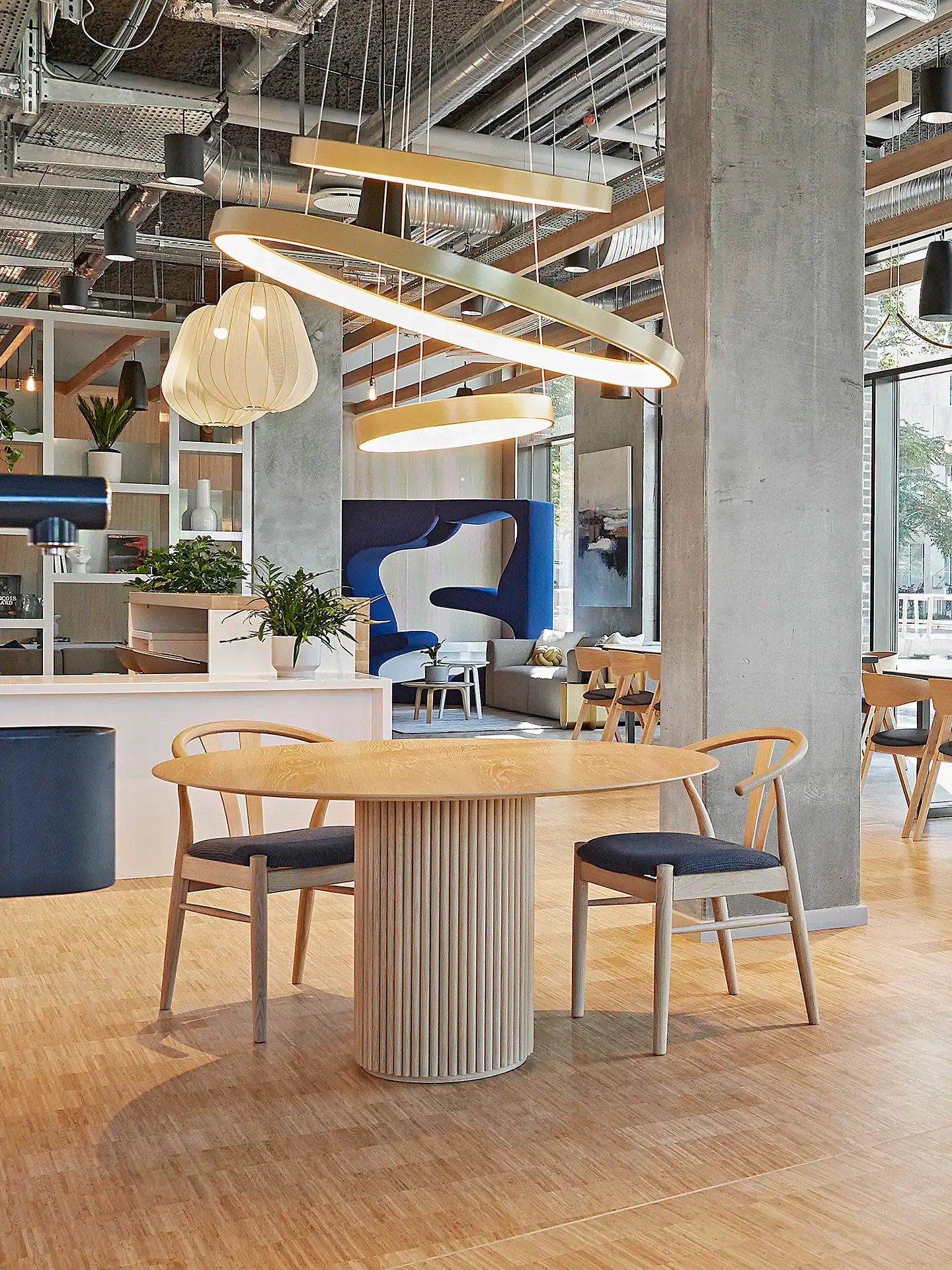 Award winning student living interior design. Contempory design with wooden tablesetting, concrete and big round lamps.