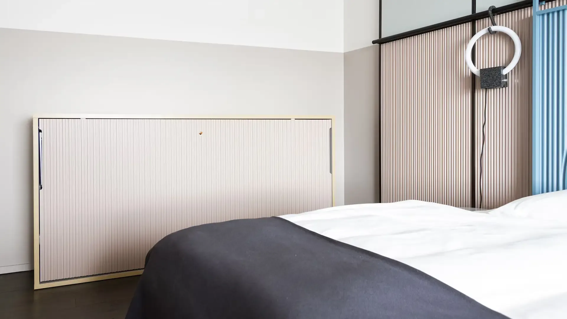 Hotel bed with fold-down wall system and modern interior