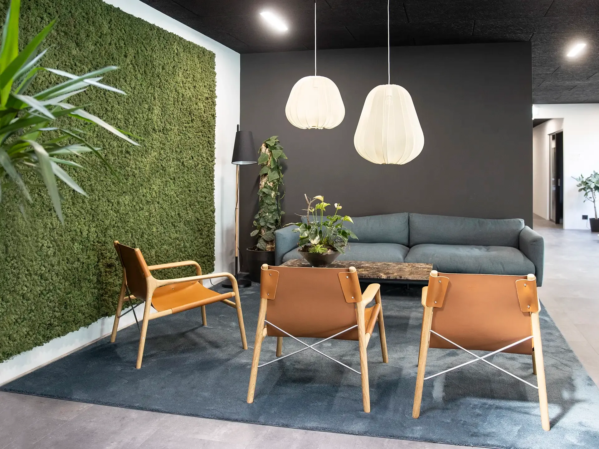 Lounge area featuring Bolia furniture and acoustic moss wall, combining tactile materials with a calming visual identity.
