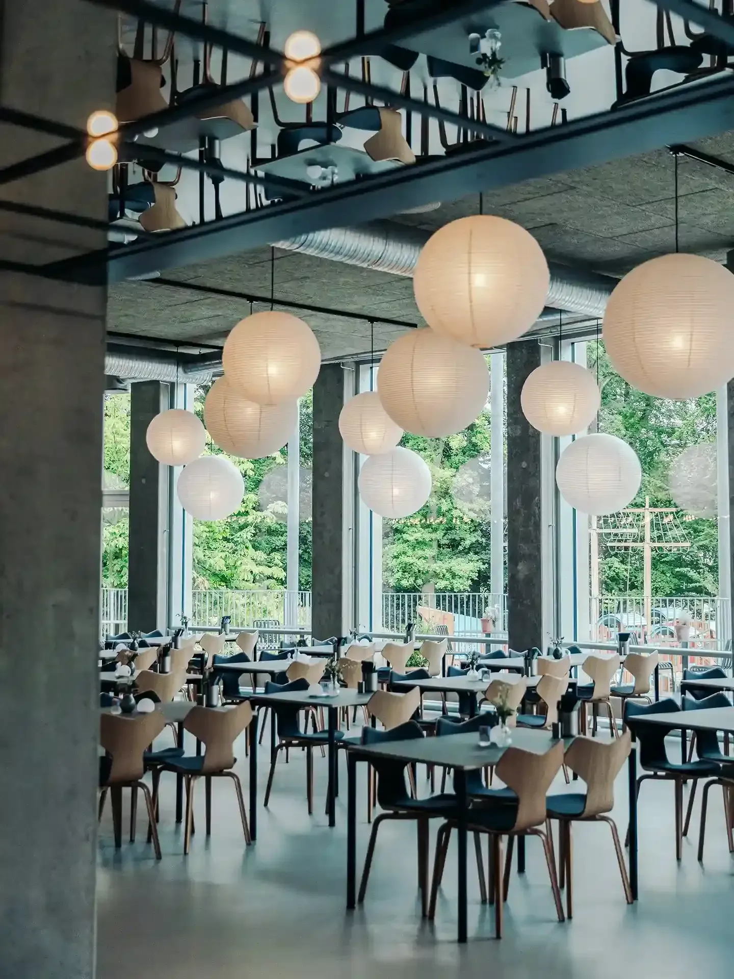 Nordic-inspired restaurant layout with designer dining chairs by Fritz Hansen, combining timeless form with functional seating.